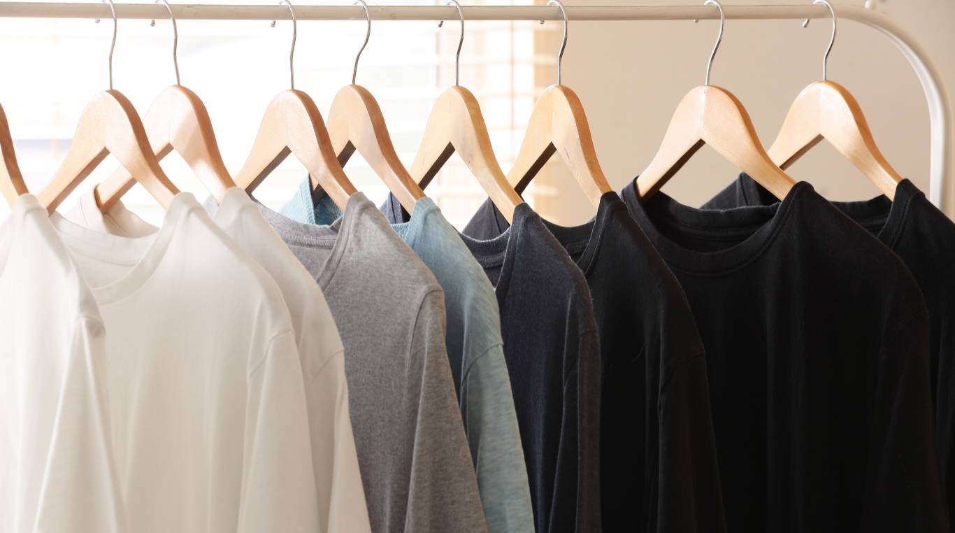 Tees on wooden hangers in white, gray, and black